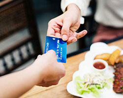 close shot of person passing credit card to another person