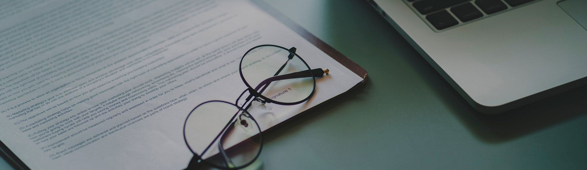 close-up of laptop document and glasses on table