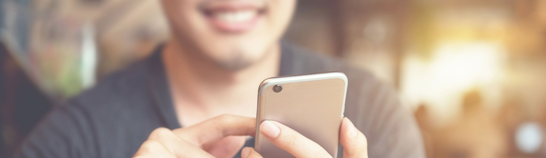 close-up of smiling man using smartphone