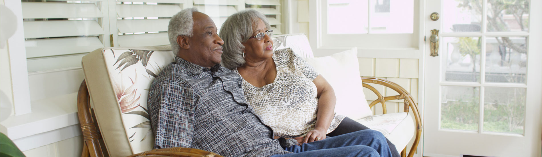 elderly couple sitting together on couch