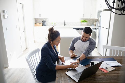 Middle aged man and woman sitting at a table looking over paperwork